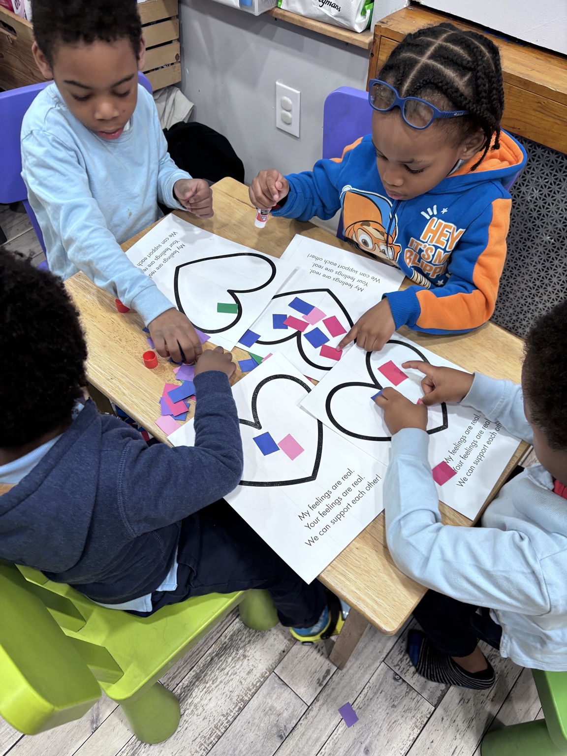 Children making heart crafts together